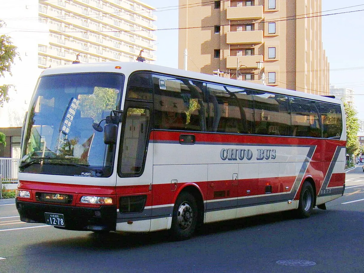 Red and white Hokkaido Chuo Bus highway coach on a city street