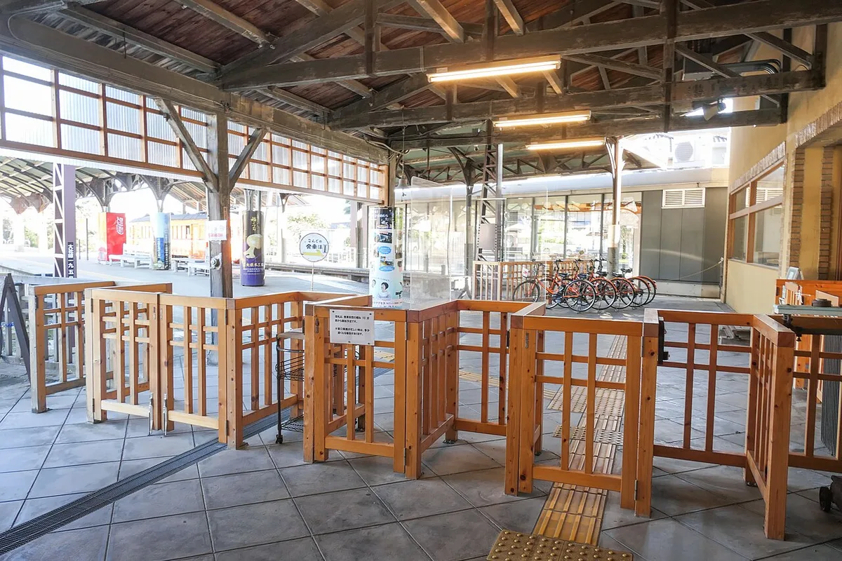 Wooden ticket gates under the platform roof at Izumotaisha-mae Station