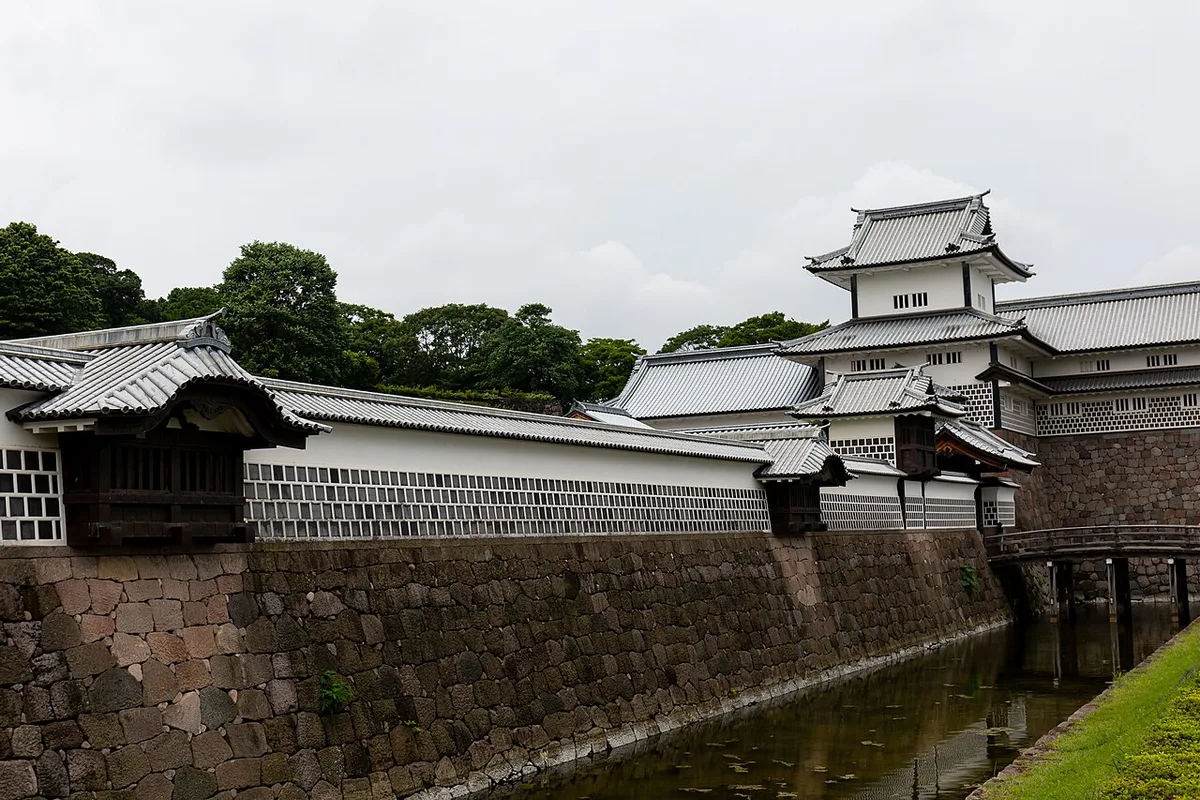 Hishi Yagura turret and the white Gojukken Nagaya storehouse on stone walls above the moat at Kanazawa Castle Park