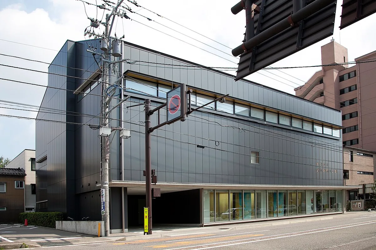 Dark modern building of the Yasue Gold Leaf Museum on a street corner in Kanazawa