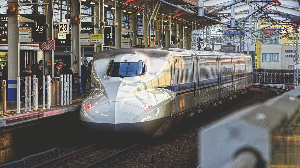 A white N700 series Shinkansen arriving at a platform of Okayama Station