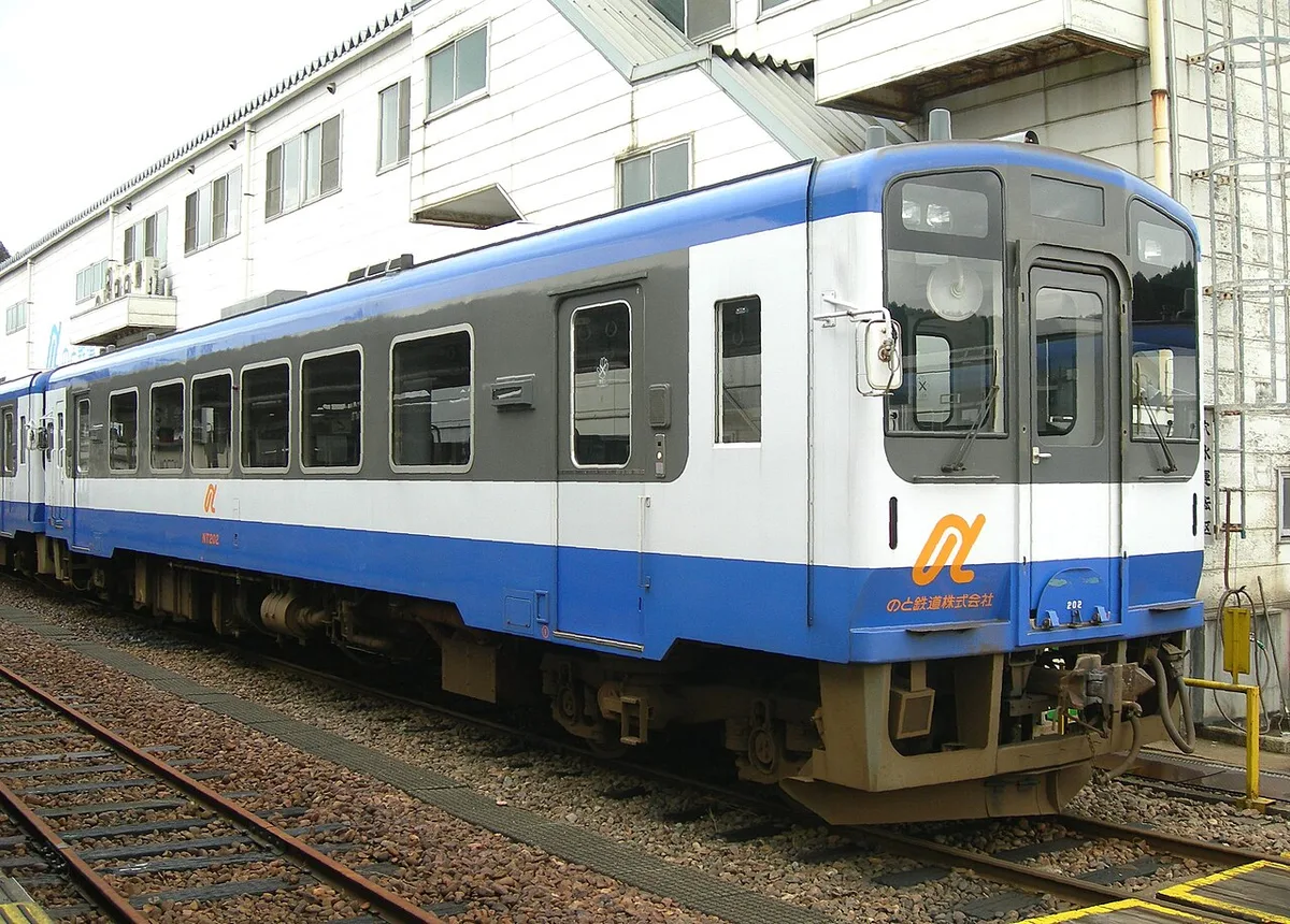 Blue and white Noto Railway diesel railcar at a station