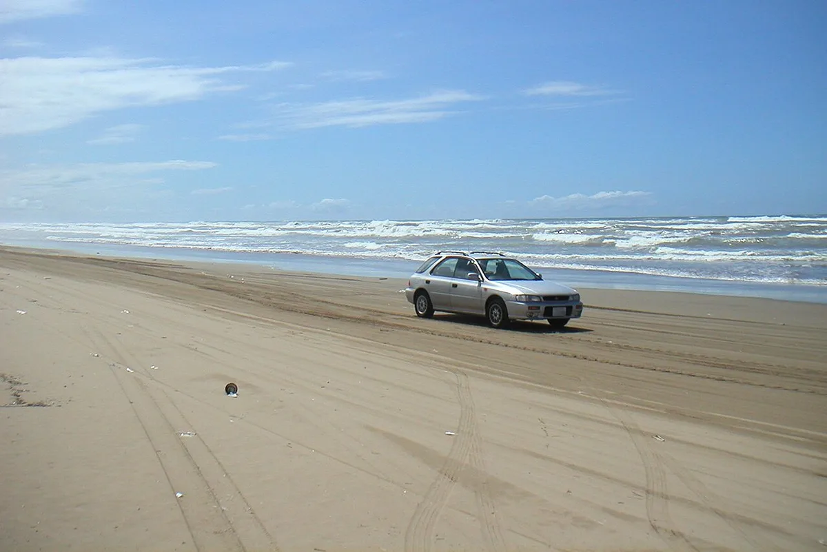 A car driving on the sand of the Chirihama Nagisa Driveway beside the Sea of Japan, Hakui