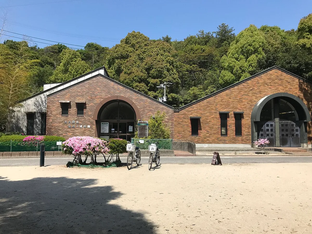 Brick building of the Okunoshima Poison Gas Museum with azaleas and bicycles in front