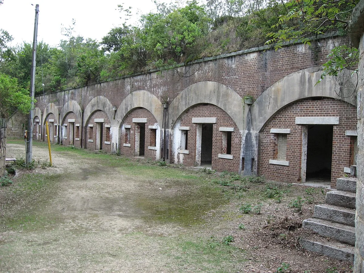 Arched brick and concrete rooms of former gun battery ruins among trees on Okunoshima
