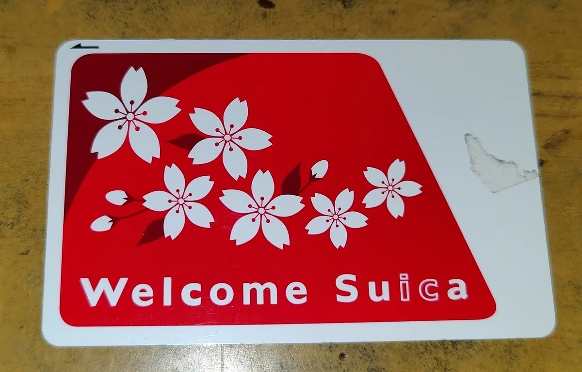 A Welcome Suica card: white with a red cherry-blossom design and the words Welcome Suica