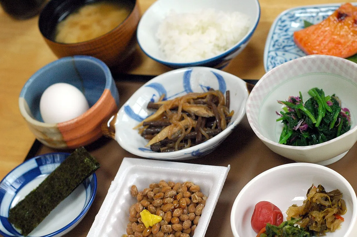 Japanese breakfast at Azuma Ryokan: rice, miso soup, grilled salmon, natto, a raw egg, nori, greens and pickles in small dishes on a tray