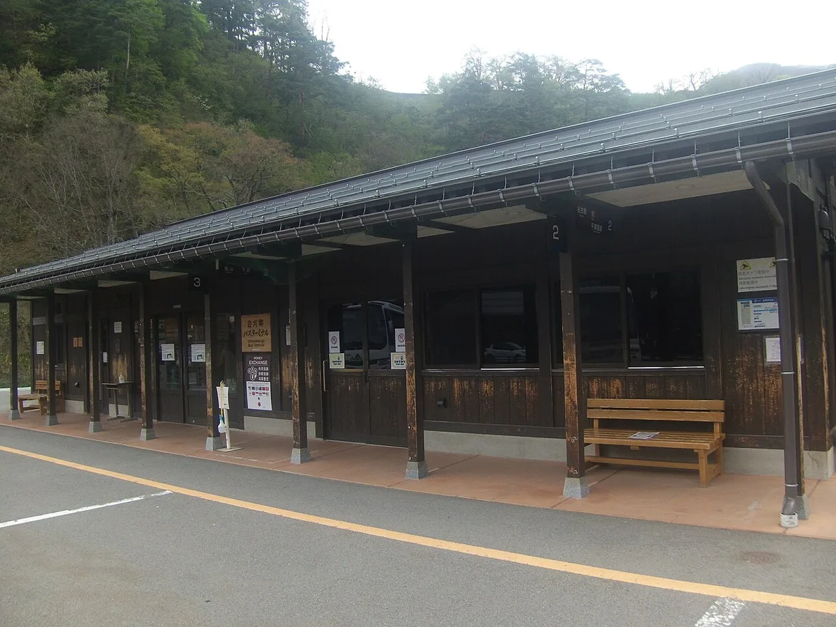Shirakawago Bus Terminal, a long wooden shelter with numbered boarding bays and benches, Shirakawa-go