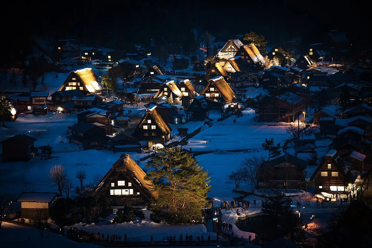 Snow-covered thatched gassho-zukuri farmhouses lit up at night in Ogimachi, Shirakawa-go