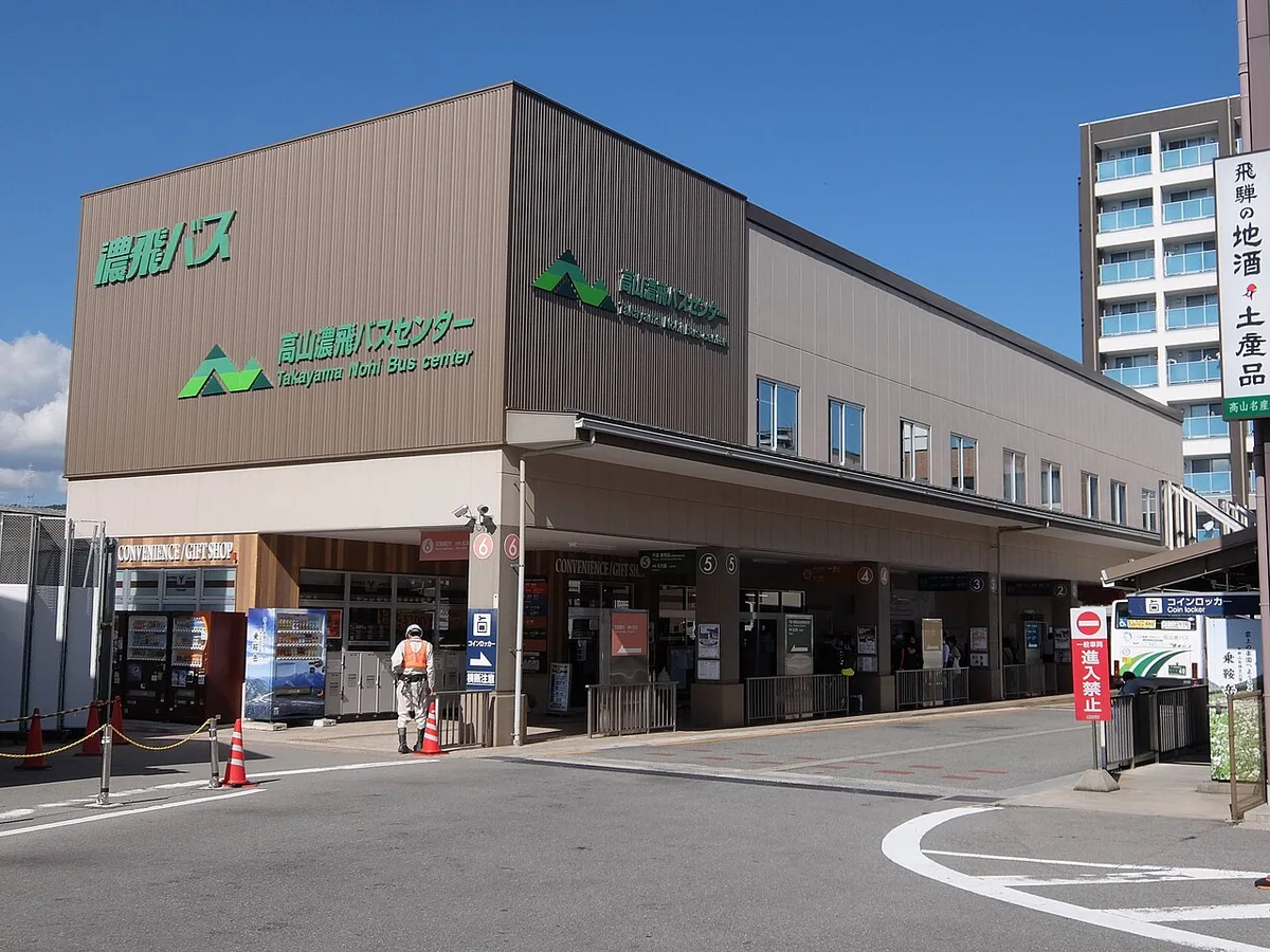 Takayama Nohi Bus Center, a brown two-storey bus station with numbered boarding bays and a coin locker sign