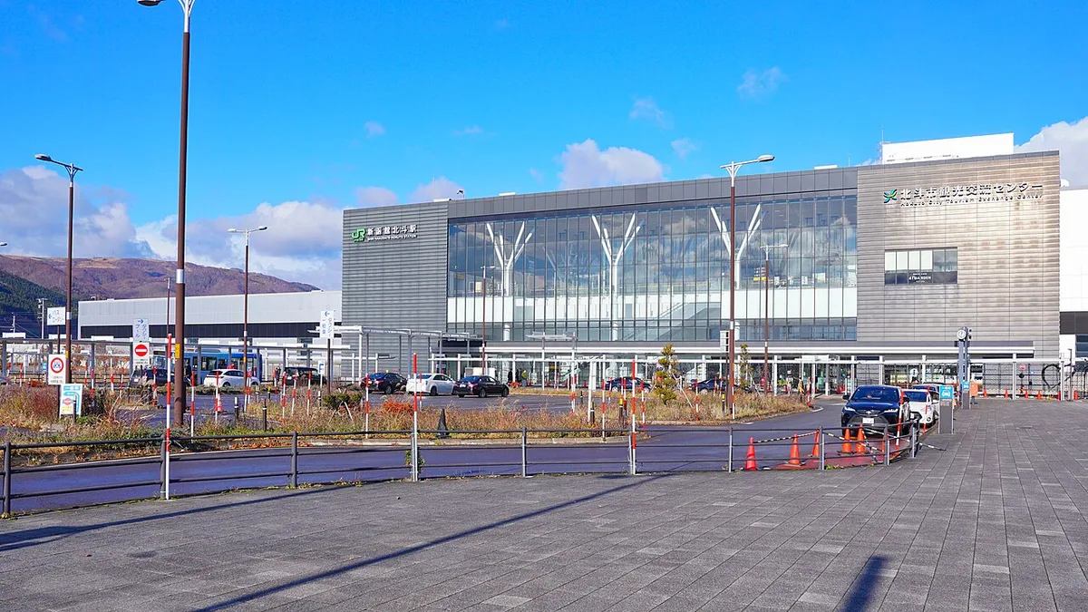 Glass-fronted building of Shin-Hakodate-Hokuto Station seen across its forecourt