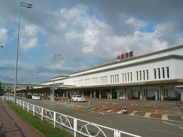 White terminal building of Komatsu Airport with its name sign on the roof