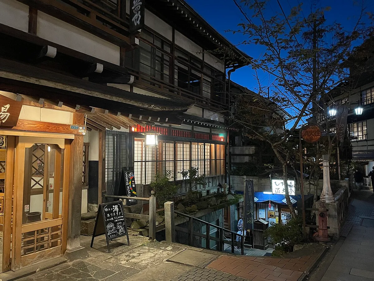 Wooden entrance of the Ō-yu public bath in Shibu Onsen, lit at dusk